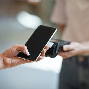 wireless-payment-close-up-female-hand-using-smartphone-paying-contactless-at-cafe-e1630657518998.jpg